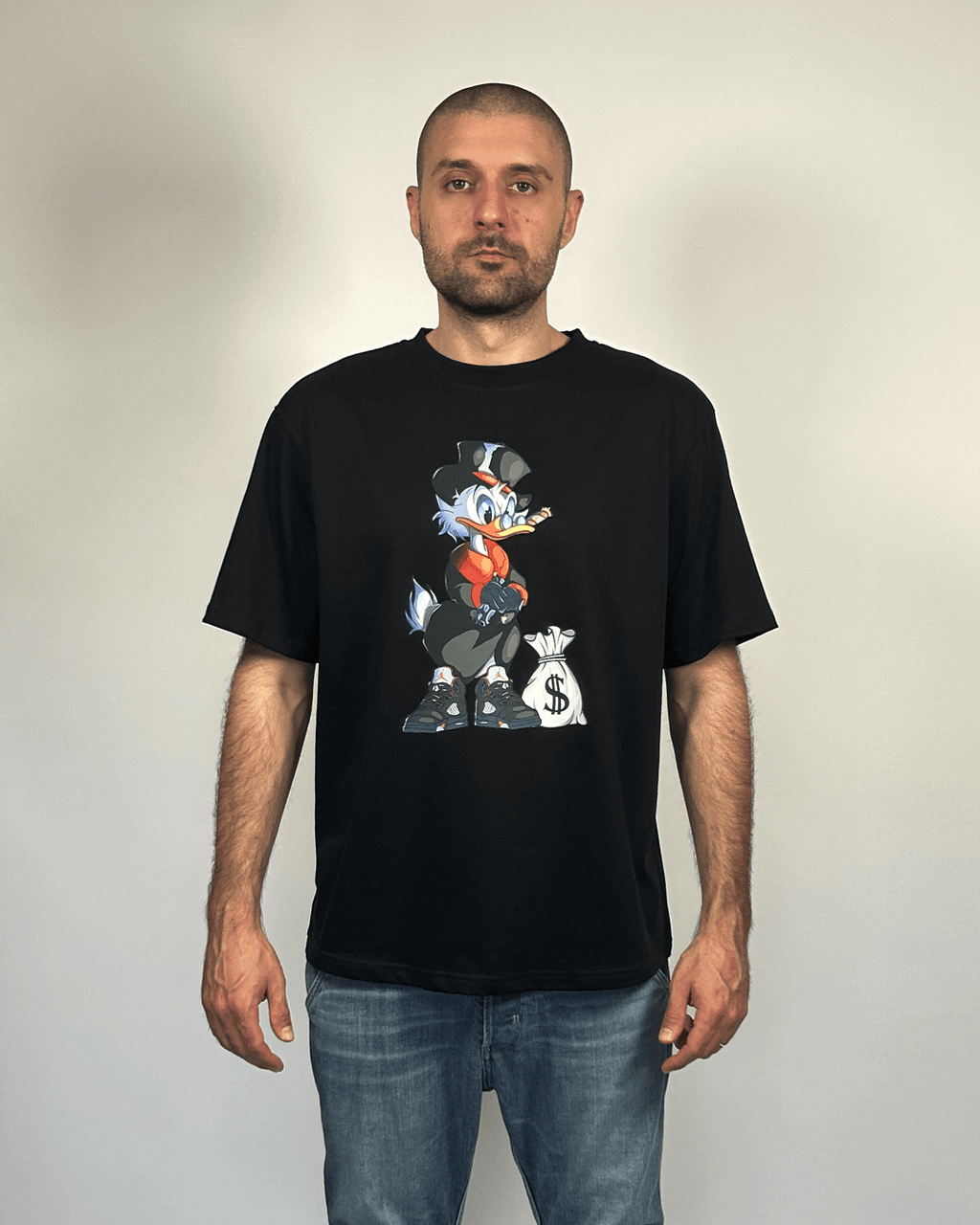 Тениска със свободен силует, свеж дизайн на лош паток, плътен памук, черен цвят. Показана върхъ мъж